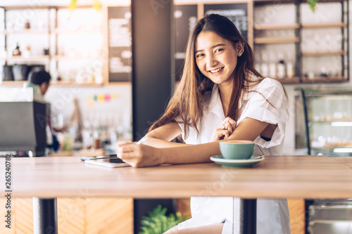 woman in a cafe drinking coffee .Portrait of Asian woman smiling in coffee shop cafe vintage color tone