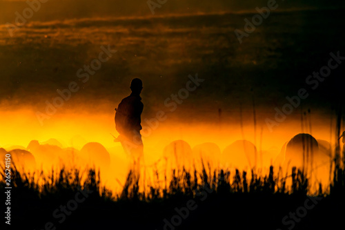 Sunset and shepherd. Red and black nature background. 