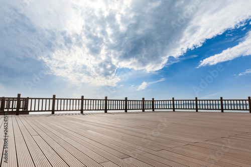 Lakeside wood floor platform and blue sky with white clouds