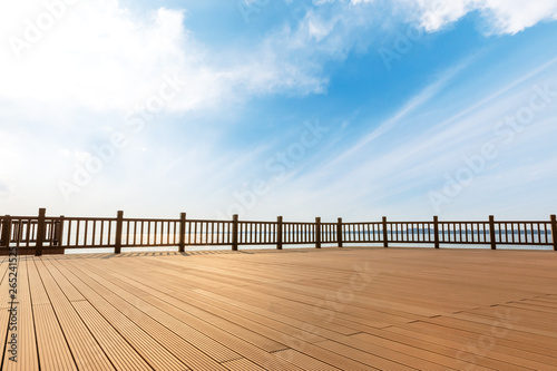 Lakeside wood floor platform and blue sky with white clouds