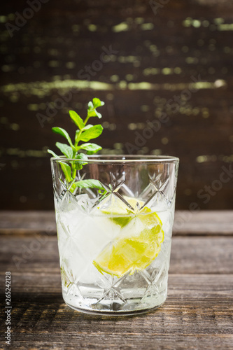 Old fashioned beverage with lime and mint leaves. Selective focus. Shallow depth of field.