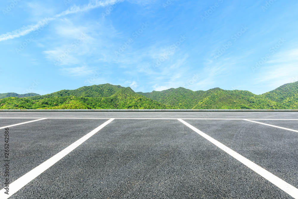Parking lot pavement and green mountains natural landscape under the blue sky Parking lot pavement and green mountains natural landscape under the blue sky