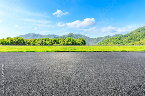 Fototapeta Naklejka Na Ścianę i Meble -  Country road and green mountains natural landscape under the blue sky