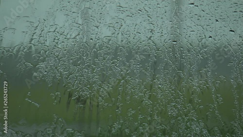 window under the rain big drop coming down in the window with back blurred