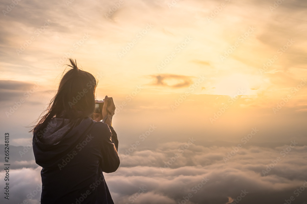 Asian women with camera Travel Holiday Relaxation Concept , Vintage Style,sunrise clouds on top of mountain with misty.enjoying beautiful cloudscape