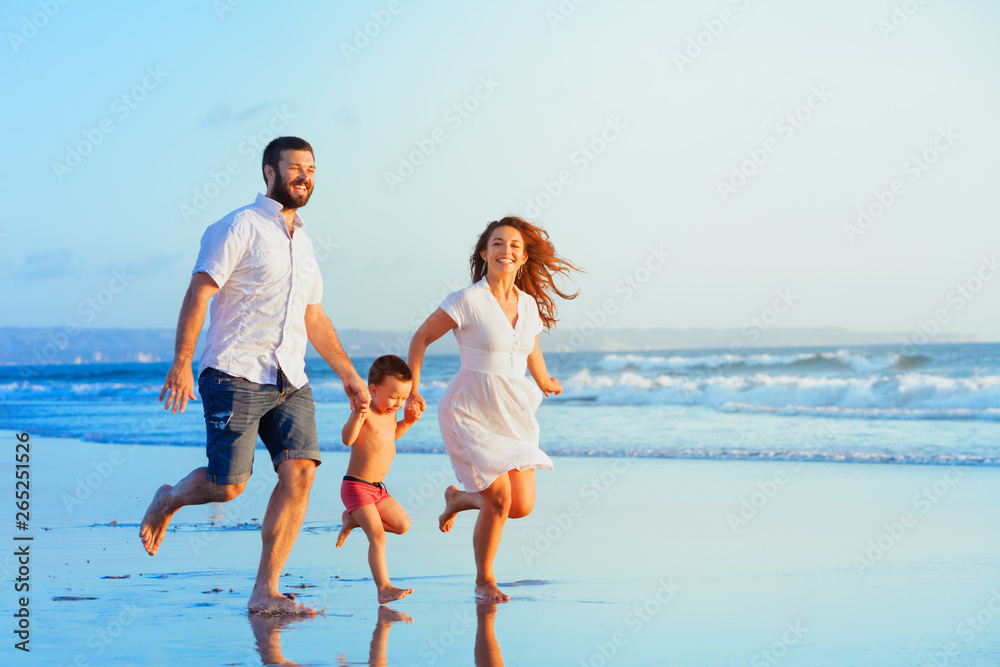 Happy family - young father, mother, baby son run together, child jump with fun by water pool along sunset sea surf on tropical beach. Travel lifestyle, people walking with kid on summer vacation Happy family - young father, mother, baby son run together, child jump with fun by water pool along sunset sea surf on tropical beach. Travel lifestyle, people walking with kid on summer vacation