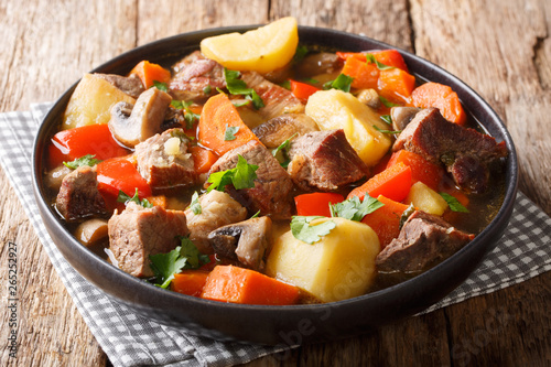 Homemade pork stew with seasonal vegetables closeup on a plate. horizontal