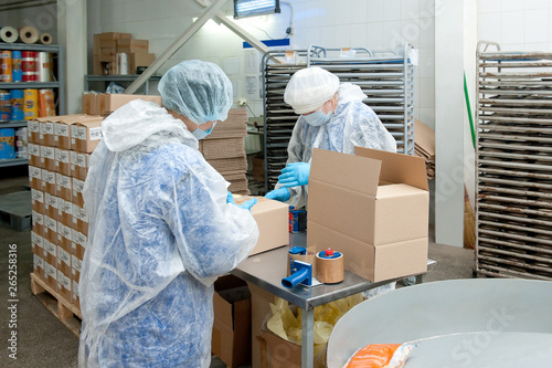 Women packer put the goods in the boxes in factory photo