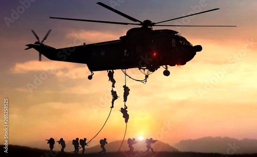 Fotografie, Tablou Military commando helicopter drops in silhouette during sunset