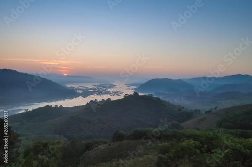sunrise at Phu Huay Esan View Point, view of the hill around with sea of mist above Mekong river with blue sky background, Ban Muang, Sang Khom District, Nong Khai, Thailand.