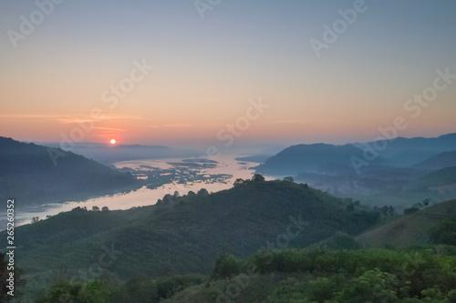 sunrise at Phu Huay Esan View Point, view of the hill around with sea of mist above Mekong river with blue sky background, Ban Muang, Sang Khom District, Nong Khai, Thailand.
