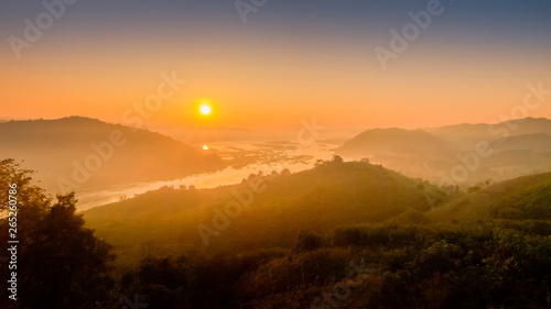 sunrise at Phu Huay Esan View Point, view of the hill around with sea of mist above Mekong river with red sun light in the sky background, Ban Muang, Sang Khom District, Nong Khai, Thailand.