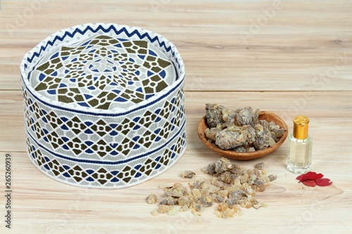 Men traditional muslim cap, frankincense and rose perfume. Typical local products from Oman on wooden table