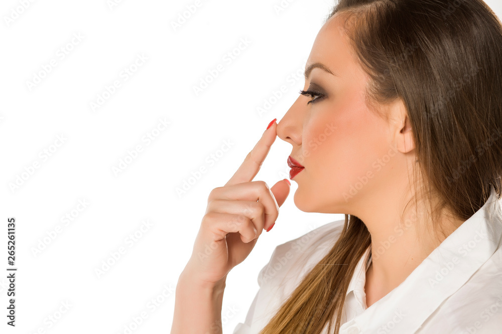 Beautiful woman touching her nose on white background Beautiful woman touching her nose on white background