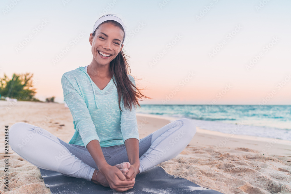 Yoga fitness beach woman stretching legs laughing. Happy Asian girl smiling during morning health workout. healthy active lifestyle.