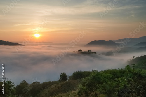 sunrise at Phu Huay Esan View Point, view of the hill around with sea of mist above Mekong river with soft red light in the sky background, Ban Muang, Sang Khom District, Nong Khai, Thailand.