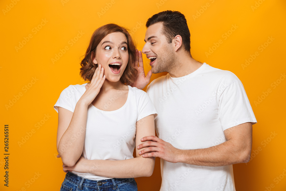 Naklejka premium Excited beautiful couple wearing white t-shirts standing