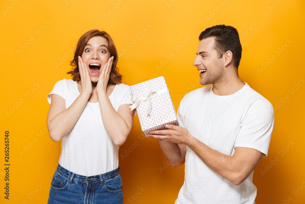 Excited beautiful couple wearing white t-shirts standing Excited beautiful couple wearing white t-shirts standing