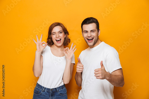 Excited beautiful couple wearing white t-shirts standing