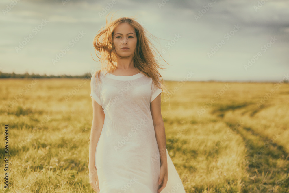 Portrait of beautiful girl in field. Beautiful blond girl on green field with flowers. Rural scene Portrait of beautiful girl in field. Beautiful blond girl on green field with flowers. Rural scene