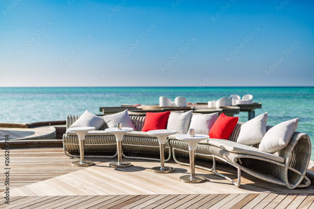 Outdoor beach sofa and loungers on wooden deck with sea view Outdoor beach sofa and loungers on wooden deck with sea view