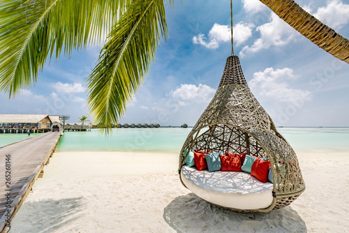Fototapeta Naklejka Na Ścianę i Meble -  Chill lounge zone on the sandy beach, Maldives island. Beautiful tropical Maldives beach under cloudy sky with swings on coconut palm. Luxury vacation
