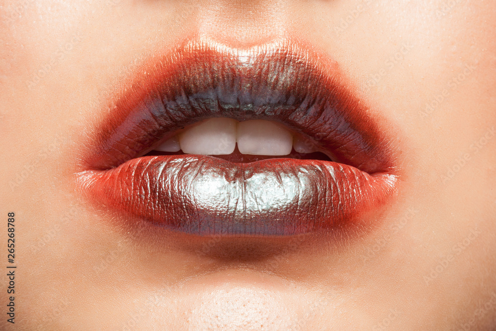 Fototapeta premium Close up view of beautiful woman lips with orange lipstick.
