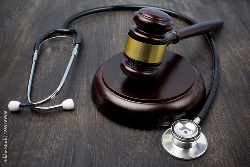 Gavel and stethoscope on black wooden background