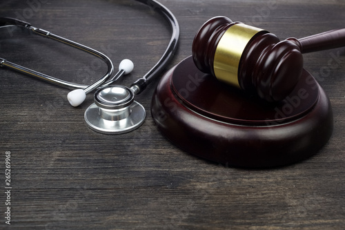 Gavel and stethoscope on black wooden background