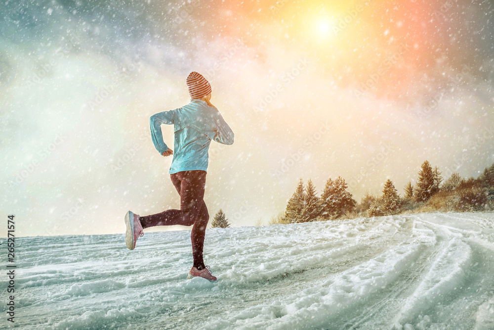 Fototapeta premium Running woman. Runner on the snow in winter sunny day. Female fi