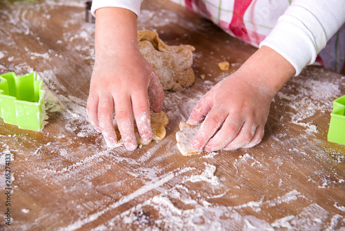 Child Chef preparing the dough. Closeup girl's chef's hands with dough and flour, food preparing process