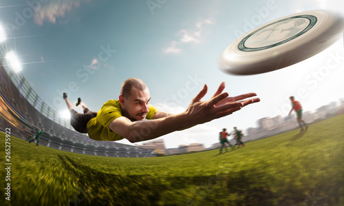 plyear play ultimate flying disc in stadium. Around beautiful sunny day photo