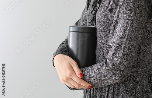 Obraz na płótnie Woman with mortuary urn on light background