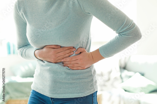 Fototapeta Naklejka Na Ścianę i Meble -  Young woman suffering from stomachache at home