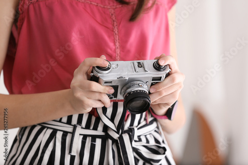 Young girl with photo camera at home, closeup