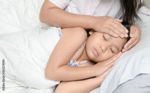 Mother measuring temperature of ill kid.