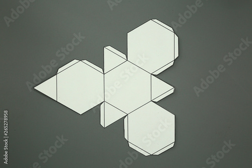 Geometric shape cut out of paper and photographed from above on grey background.Geometry net of Truncated tetrahedron. Unfolded three Dimensional Figures. Isolated. Top view.