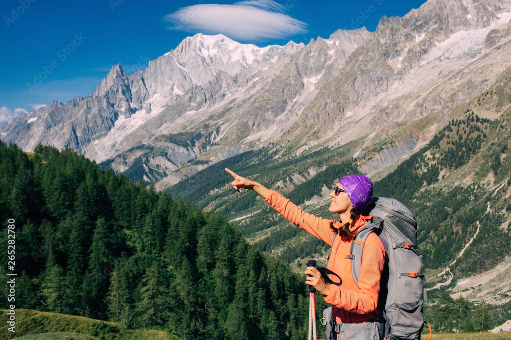 woman hiking on a mountain background, Mont Blanc massif. Travel around Mont Blanc with a backpack.