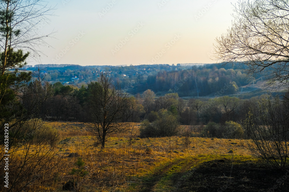 Landscape with the image of spring countryside in Tula region in Russia at sunset