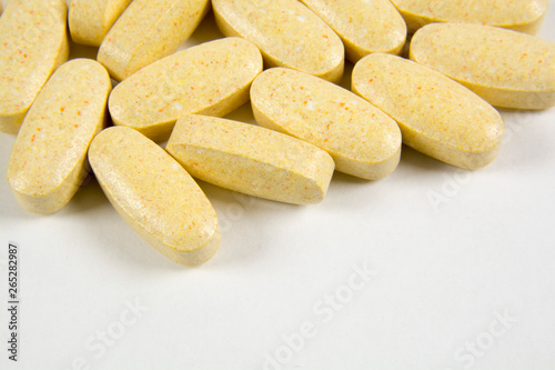 Pills scattered on a gray background. The photo shows vitamins for hair growth