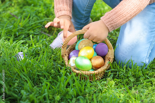 Photography Little girl gathering Easter eggs in park, closeup