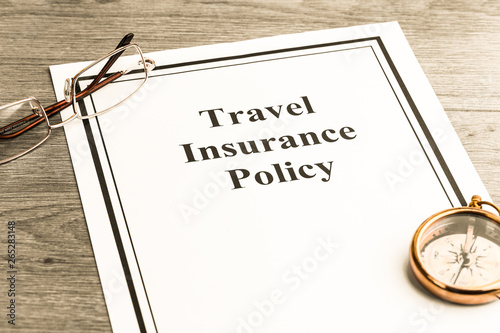 Travel insurance policy with glasses and compass on table. Business concept