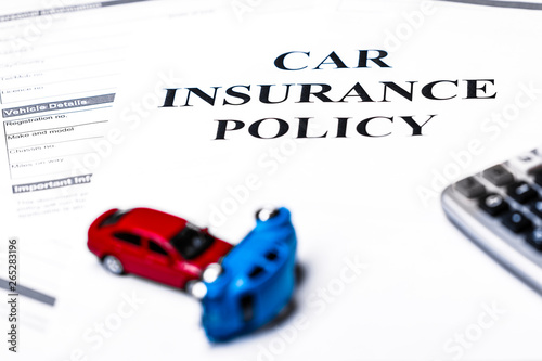 Car insurance policy. Document, models of cars and calculator on table. Business and insurance background concept.