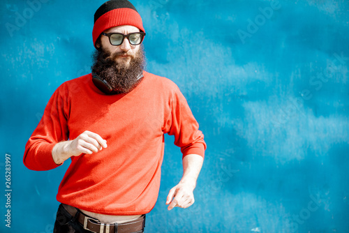 Portrait of a stylish man in red sweater and hat dancing on the colorful background © rh2010