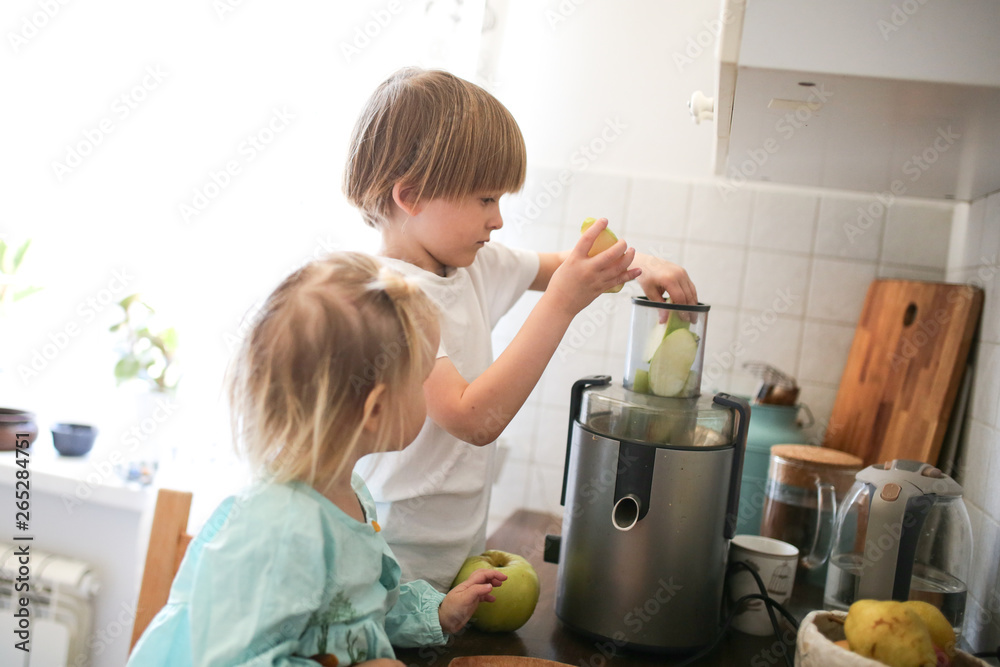 children with juicer squeeze out juice from apples children with juicer squeeze out juice from apples