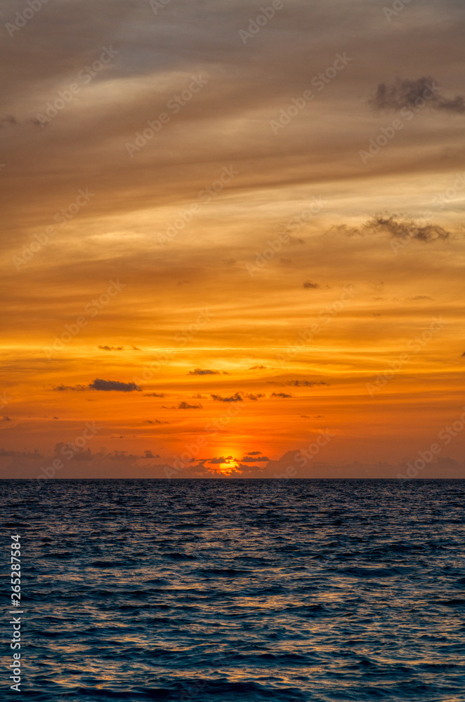 Vertical view of the sea horizon with deep blue  waters and oranges colors sunset in Maldives
