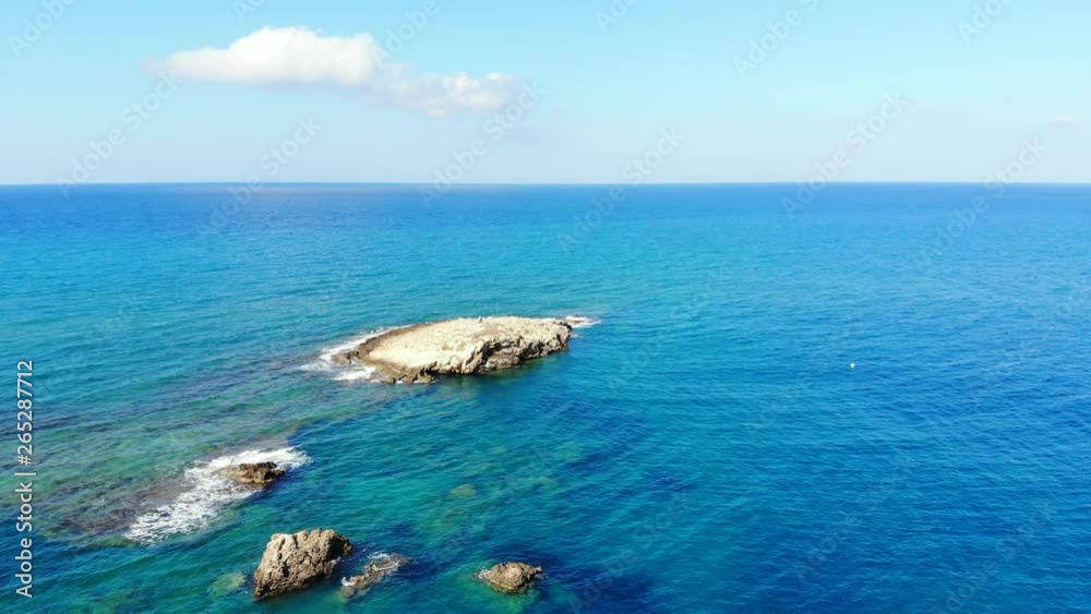 Rock sink in sea, cape at north of Crete Island, beautiful blue water of Aegean Sea till horizon. Sunny weather, small waves on surface. Bottom seen through clear and transparent seawater Rock sink in sea, cape at north of Crete Island, beautiful blue water of Aegean Sea till horizon. Sunny weather, small waves on surface. Bottom seen through clear and transparent seawater