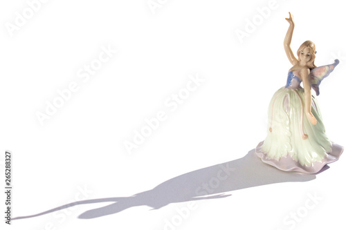porcelain figurine of a dancer in a dress with wings and shadow isolated