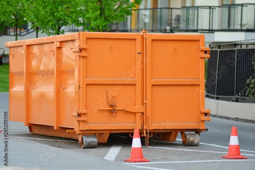 Orange colored dump bin at open space