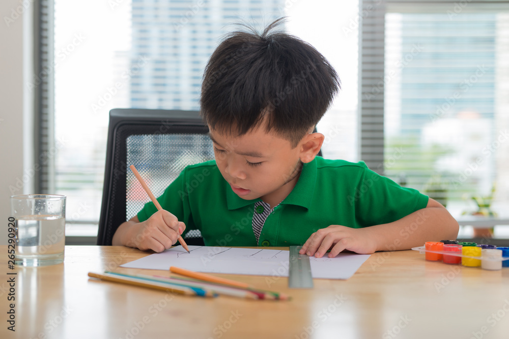 Cute boy is drawing using color pencils, isolated over white Cute boy is drawing using color pencils, isolated over white